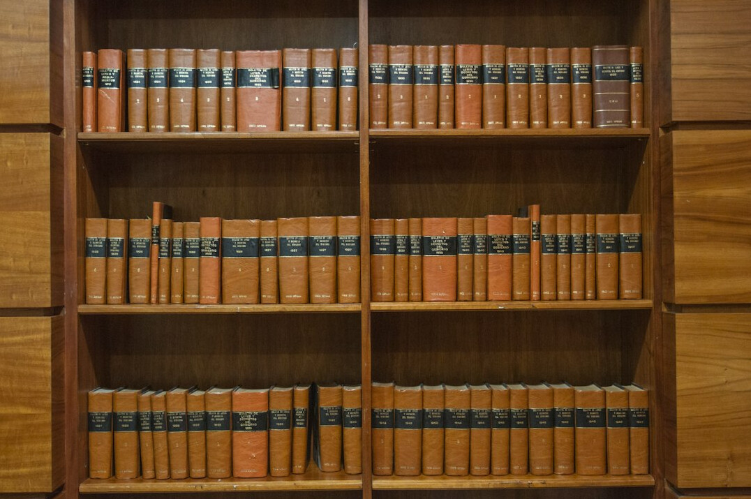 Legal books and a gavel on a wooden desk